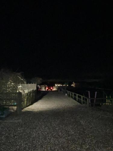 a car driving down a road at night at The Goose lodge in Calveley
