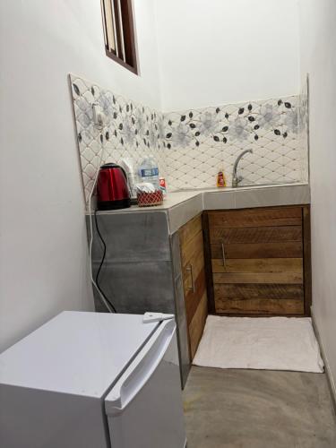 a small kitchen with a sink and a dishwasher at Tropical Villa in Galle