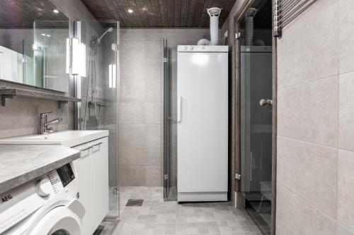a bathroom with a shower and a washing machine at RukaHillChalet4 Ski In - Ski Out in Ruka
