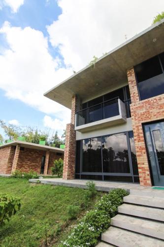 a brick house with a porch and a balcony at Farm House in Muksūdpur