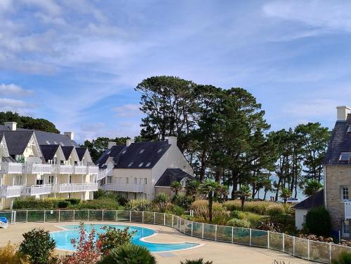 un complexe avec une piscine et des maisons dans l'établissement A07- Apt PMR 4 à 5 pers, sea view, beach, pool, à Fouesnant