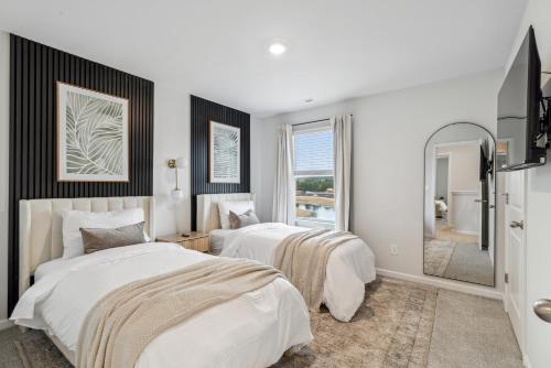 a bedroom with two beds and a mirror at Luxury 5BR Home Minutes from Wilmington Beaches in Scotts Hill