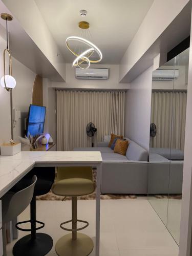 a room with a bed and a desk and chairs at Glamorous SMDC Shore 3, 5 Star Rate BnB-Wifi-Netflix in Manila