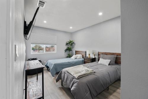 a bedroom with two beds and a flat screen tv at Spacious 4-bedroom Glendora Super House in Glendora