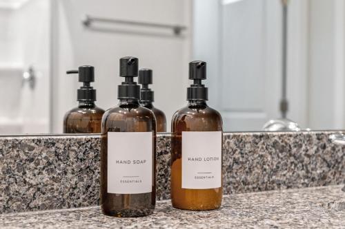 three bottles of wine sitting on a counter at Luxury 5BR Home Minutes from Wilmington Beaches in Scotts Hill