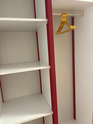 a closet with white shelves and a yellow ribbon at Esos Hotel Quelle in Bad Ragaz