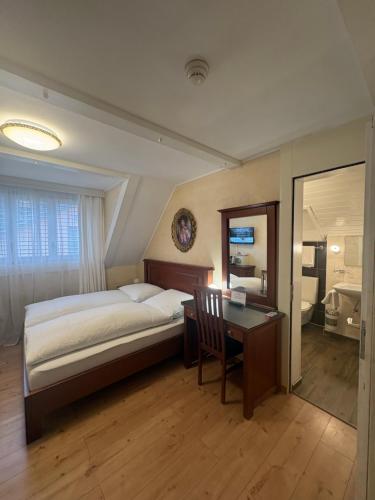a bedroom with a bed and a desk and a desk at Esos Hotel Quelle in Bad Ragaz