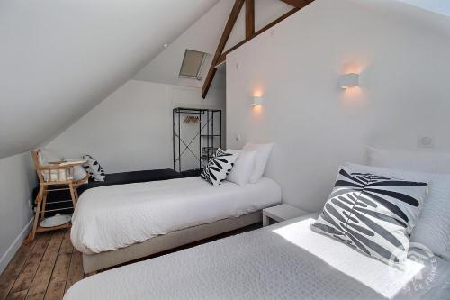 deux lits dans une chambre aux murs blancs dans l'établissement Roz vallee 1, à Perros-Guirec