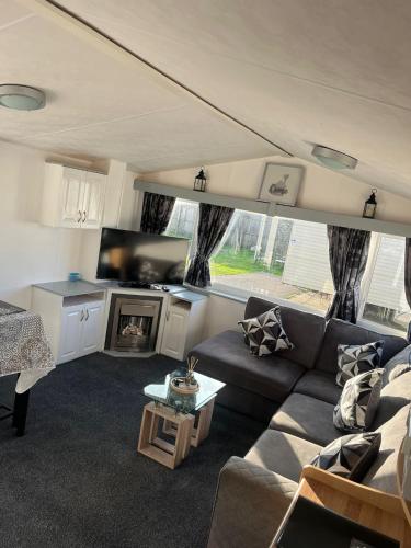 a living room with a couch and a tv at Porthcawl Trecco bay Ash91 in Newton