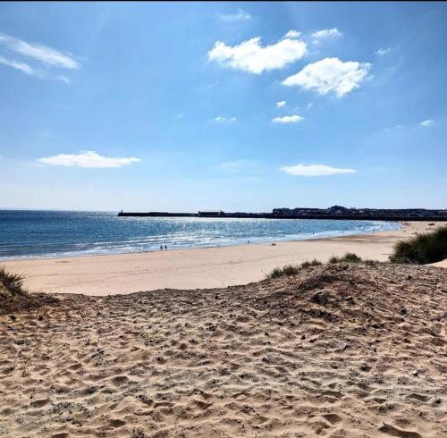 a sandy beach with a view of the ocean at Porthcawl Trecco bay Ash91 in Newton