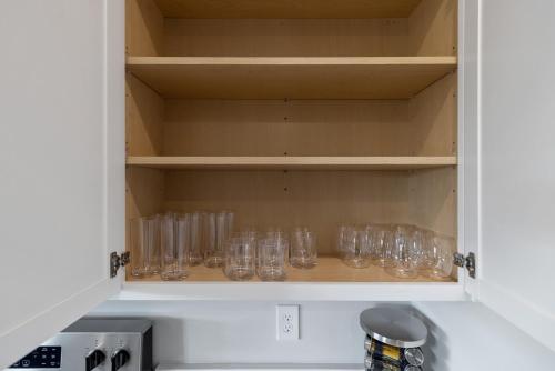 a kitchen cupboard filled with empty glass glasses at Luxury 5BR Home Minutes from Wilmington Beaches in Scotts Hill