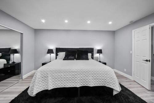 a white bedroom with a large white bed with black pillows at Spacious 4-bedroom Glendora Super House in Glendora