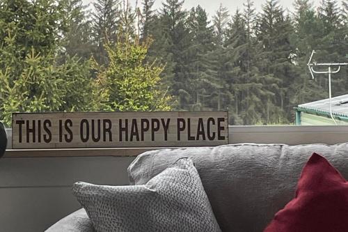 a window with a sign that reads this is our happy place at Pet Friendly Caravan - Slaley Forest - Sleeps 4 in Hexham