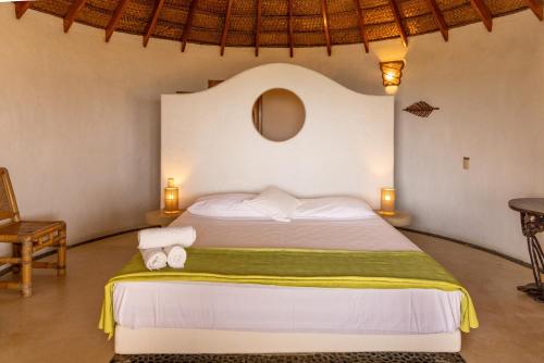 a bedroom with a bed with towels on it at Soleil Bungalows in Los Órganos
