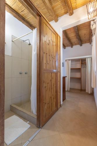a bathroom with a shower and a wooden door at Soleil Bungalows in Los Órganos
