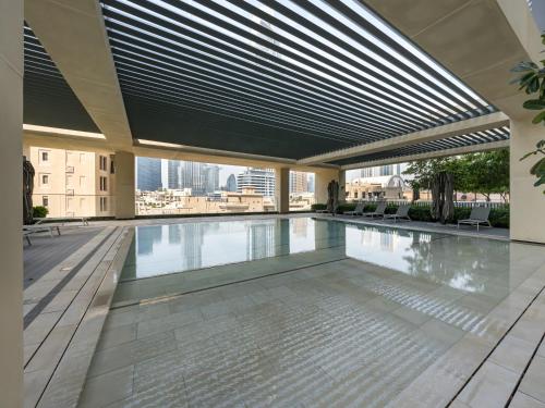 an indoor swimming pool in a building with a roof at SmartStay at Burj Royale - Unique Downtown Dubai City Views - Brand New Luxury Apartments in Dubai