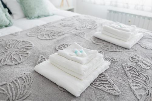 two white towels sitting on top of a bed at HeyYou Apartment in Bjelovar