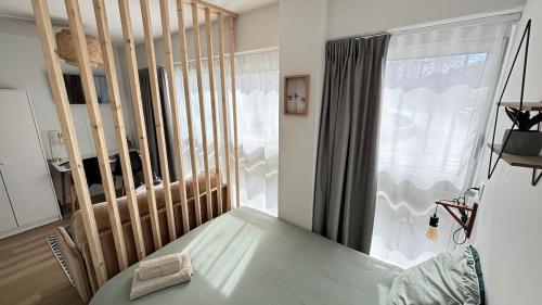 Cette chambre dispose d'une table verte et d'une fenêtre. dans l'établissement Le Pixie Modern studio Easy airport access, à Toulouse