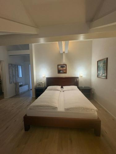 a bedroom with a large bed in a room with wooden floors at Esos Hotel Quelle in Bad Ragaz