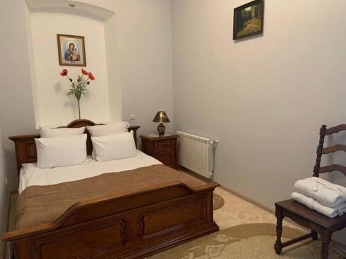 a bedroom with a bed and a chair at Hetman Hotel in Kamianets-Podilskyi