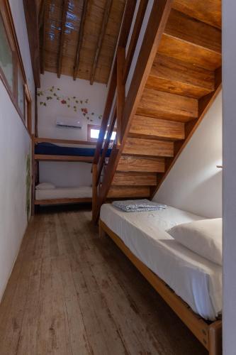 a bedroom with a bunk bed with wooden stairs at Soleil Bungalows in Los Órganos