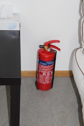 a red fire hydrant sitting next to a wall at Casa Silvia in Germignaga
