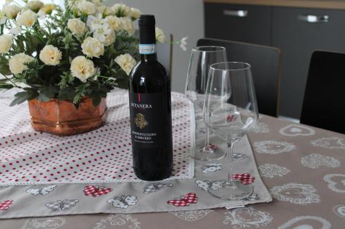 a bottle of wine sitting on a table with glasses at Casa Silvia in Germignaga