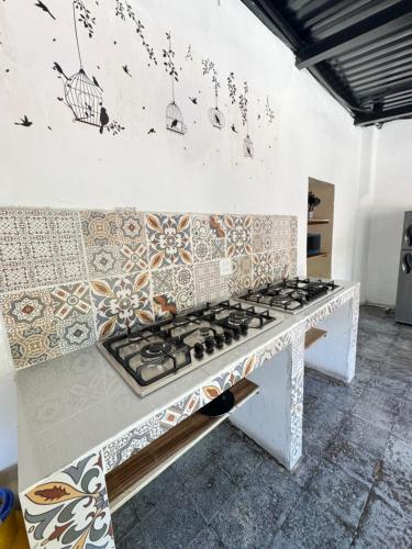 a kitchen with a stove top in a room at Urban Nest Hostel in Santa Ana