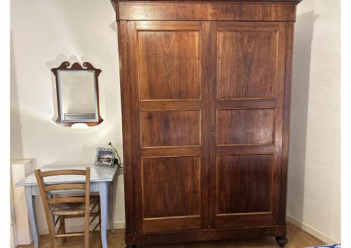 a wooden cabinet next to a table with a mirror at Frescos house in Pisa