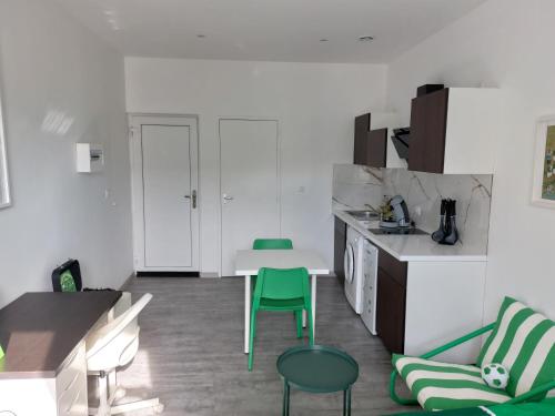 - une cuisine avec une table et des chaises vertes dans la chambre dans l'établissement Studio cosy -ALLEZ LES VERTS-, à Saint-Étienne