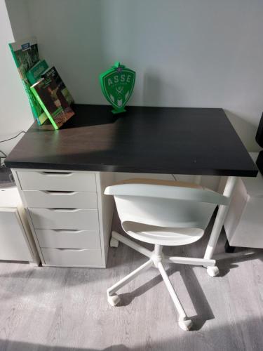 un bureau noir avec une chaise blanche devant dans l'établissement Studio cosy -ALLEZ LES VERTS-, à Saint-Étienne