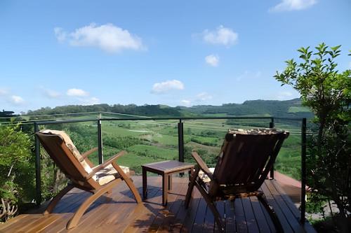 two chairs and a table on a deck with a view at Pousada Borghetto – Charme e Exclusividade no Vale dos Vinhedos in Bento Gonçalves
