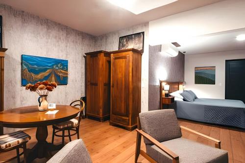 a living room with a table and a bedroom at Pousada Borghetto – Charme e Exclusividade no Vale dos Vinhedos in Bento Gonçalves