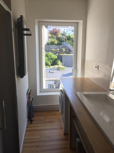 une cuisine avec un évier et une grande fenêtre dans l'établissement Duplex centre de Le Palais, au Palais