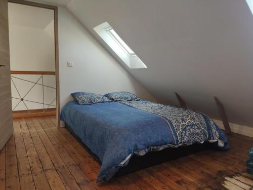 une chambre avec un lit avec une couverture bleue dans l'établissement Duplex centre de Le Palais, au Palais