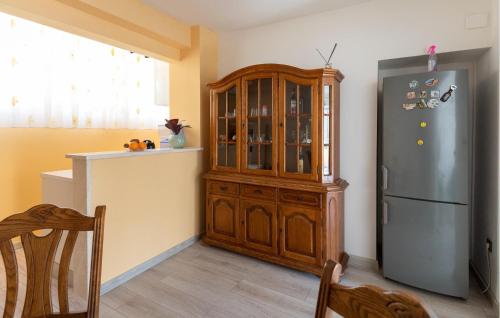 a kitchen with a wooden cabinet next to a refrigerator at 1 Bedroom Lovely Apartment In Ploce in Ploče