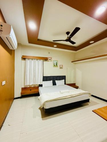 a bedroom with a bed and a ceiling fan at Vrindas Home Stay in Maheshwar