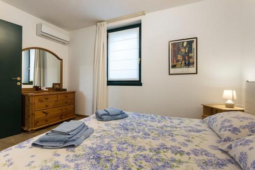 a bedroom with a bed with a dresser and a window at Ciliegio in Pavia dʼUdine