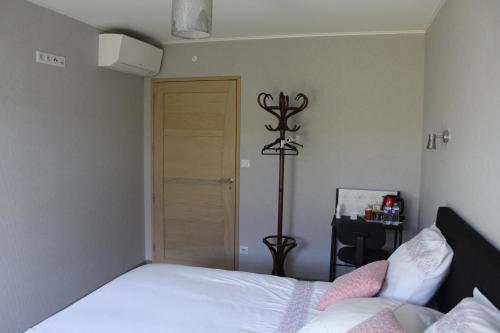 a bedroom with a bed and a wooden door at B&B La Lyre in Saint-Georges-du-Bois