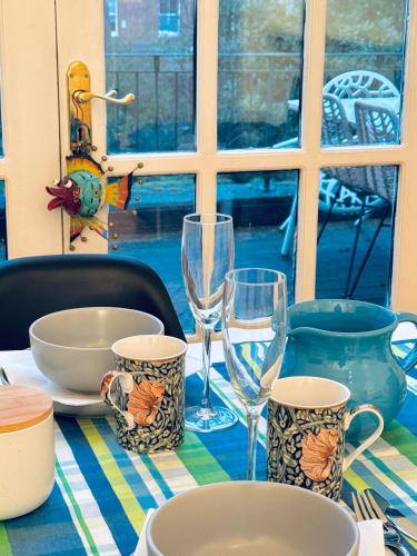 a table with glasses and plates on a table at Amazing holidays home with a terrace in London