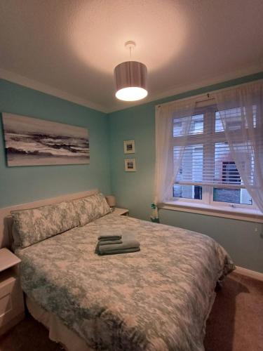 a bedroom with a large bed and a window at Old Tavern House in Fortrose