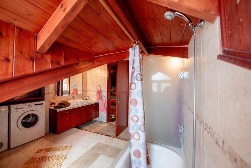 a bathroom with a tub and a sink and a washing machine at Filerimos Hillside Villa in Pastida