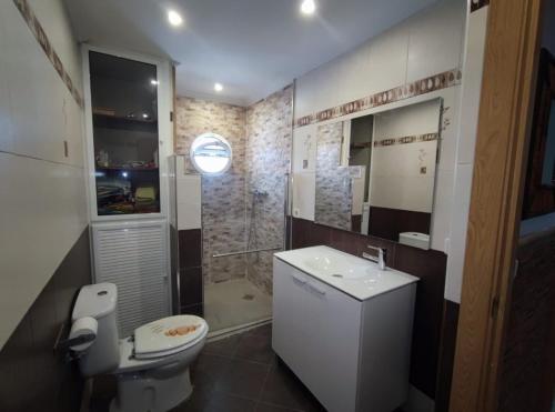 a bathroom with a toilet and a sink and a shower at La Romana in Santiponce