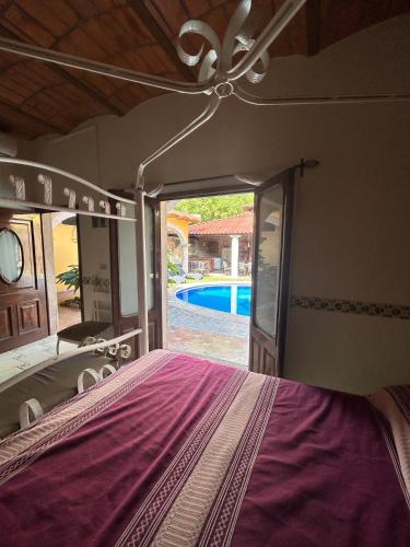 a bedroom with a bed and a pool in the background at Casa de Alegria in Lo de Marcos