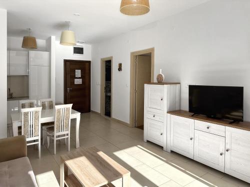 a living room with a television and a dining room at Lavender Bay D04 in Donji Morinj