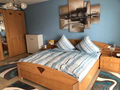 a bedroom with a bed with two paintings on the wall at Ferienwohnung Vogesenblick in Mahlberg