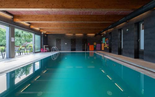a swimming pool with blue water in a building at Porčův mlýn in Býkovice