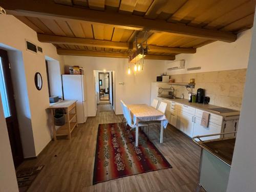 a kitchen with a table in the middle of a room at Kiskörtés Vendégház Óhuta in Háromhuta