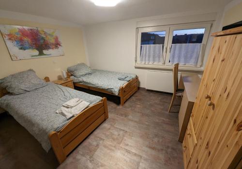 a bedroom with two beds and two windows at Pension Neue Linde in Alsfeld