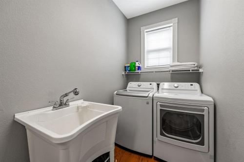 a laundry room with a sink and a washing machine at NEW King Bed,Suite,Downtown BR Southern Charm Boxcar in Blue Ridge